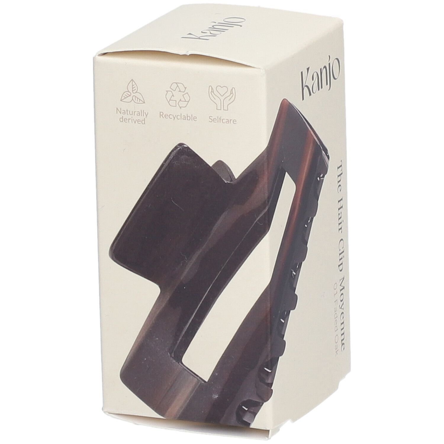 Haarspange in Verpackung. Marke: Kanjo. Aufschrift: The Hair Clip Moyenne. Braun-transparente Haarspange sichtbar.