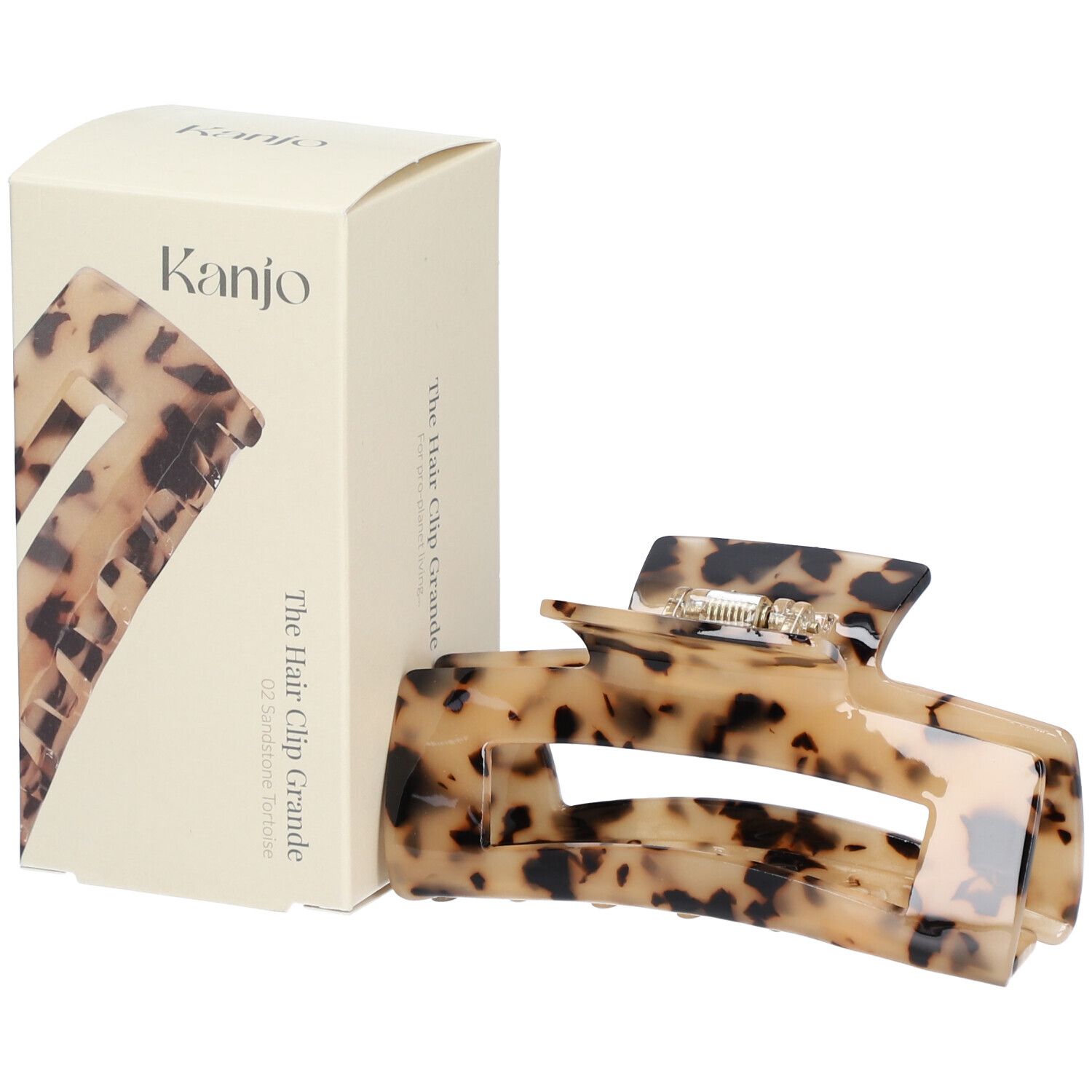 Haarspange Grande 02 Sandstone tortoise und Verpackung. Beige-braun marmoriert. Marke: Kanjo. Text: The Hair Clip Grande.