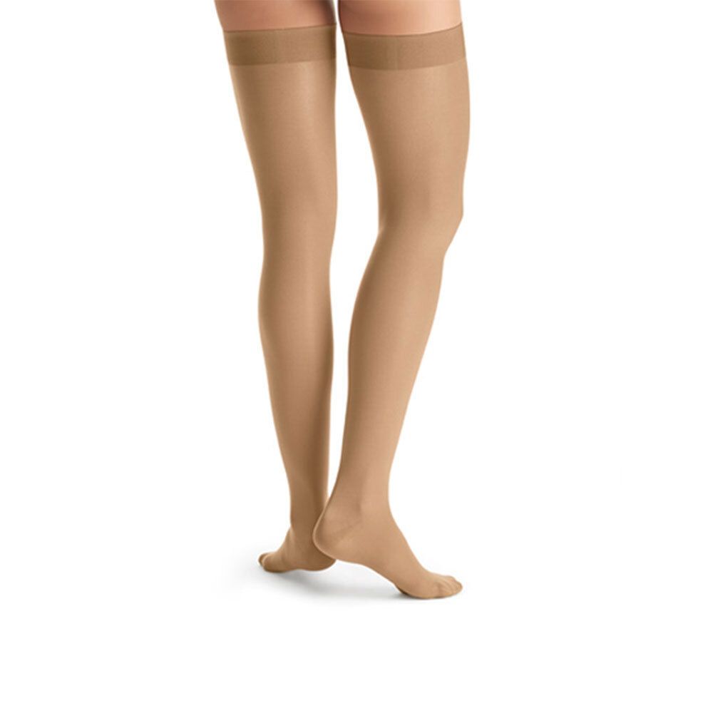 Beine mit JOBST Ultra Sheer Kompressionsstrümpfen. Hautfarbene Strümpfe, bis zum Oberschenkel reichend.