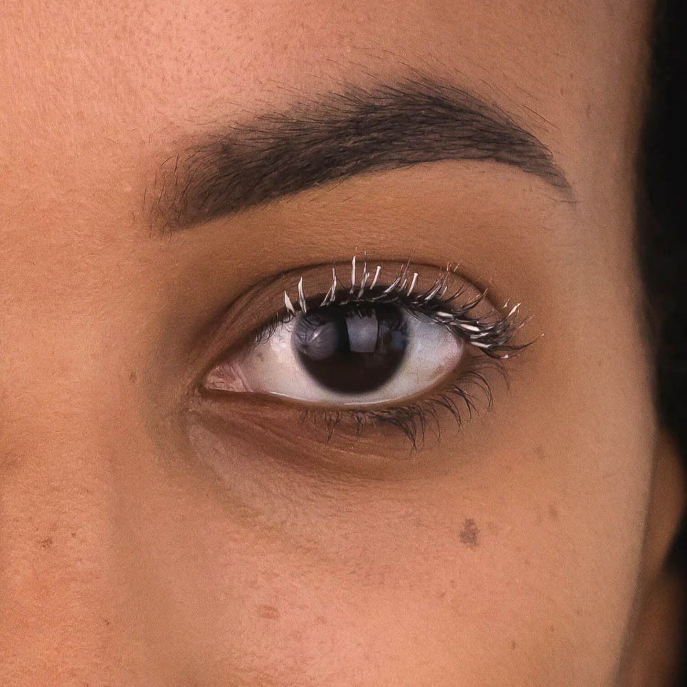 Œil avec cils maquillés. Les cils sont blancs.