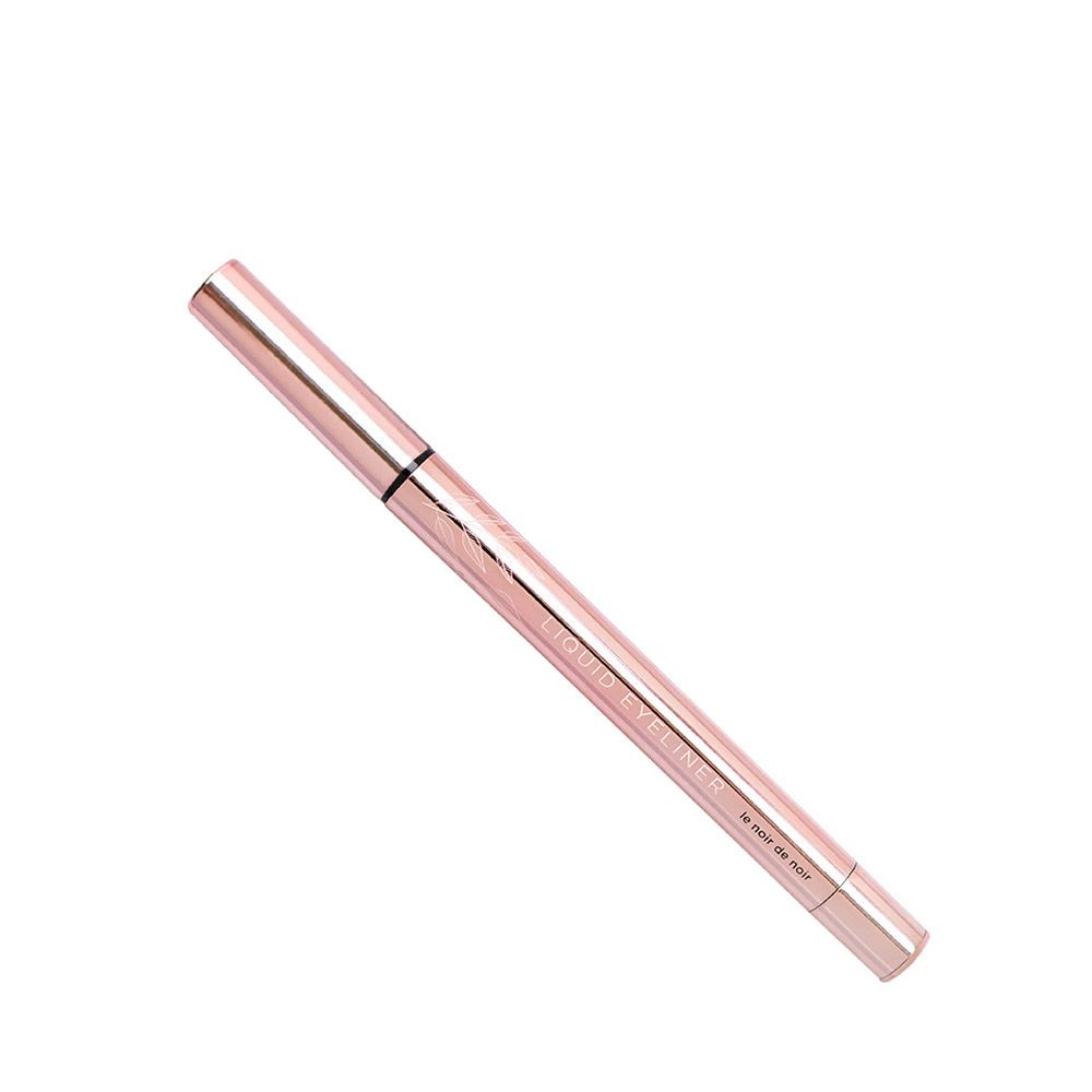 Stylo eyeliner rose. Pointe noire, gravure sur le corps.