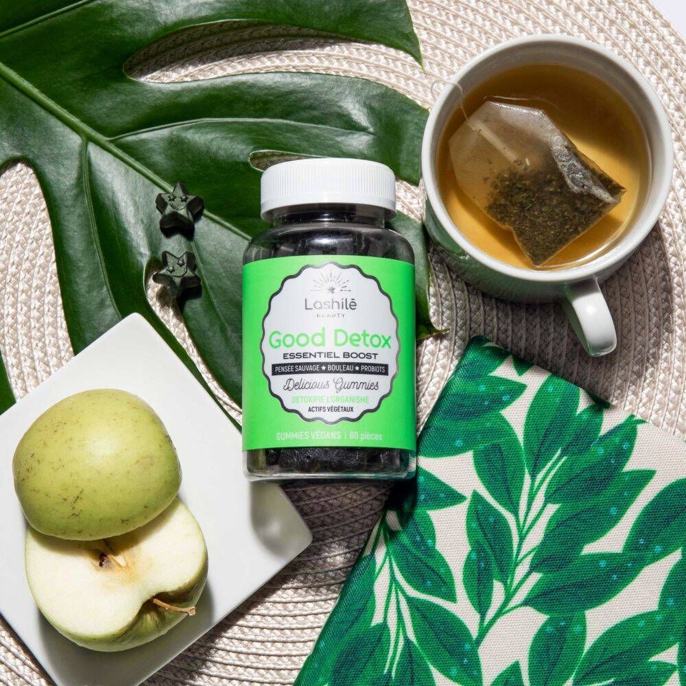 Flacon avec gummies, pomme, thé. Inscription : Good Detox, Essentiel Boost. Fond vert.