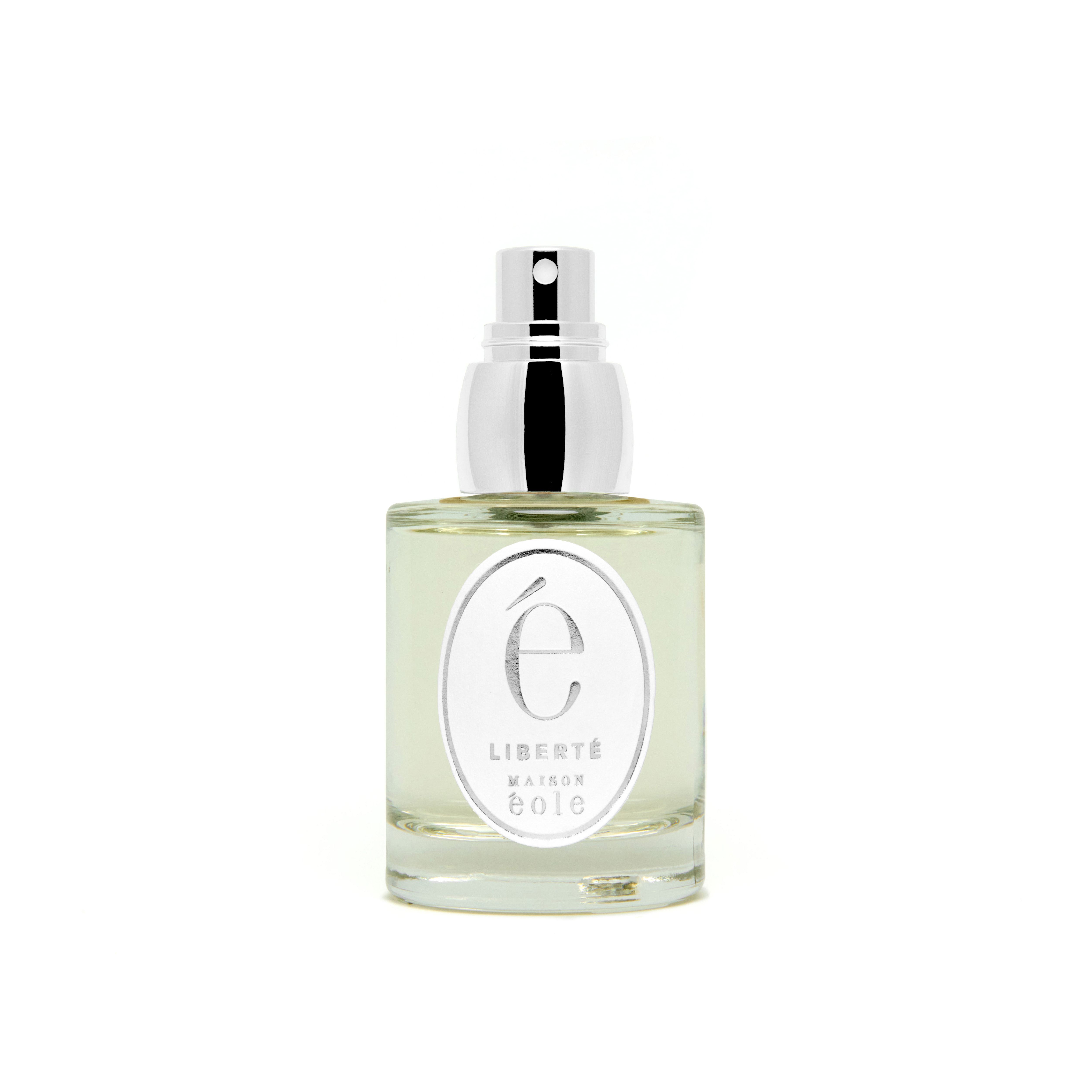 Flacon de parfum avec vaporisateur argenté. L'étiquette indique "Liberté" et "Maison Éole".
