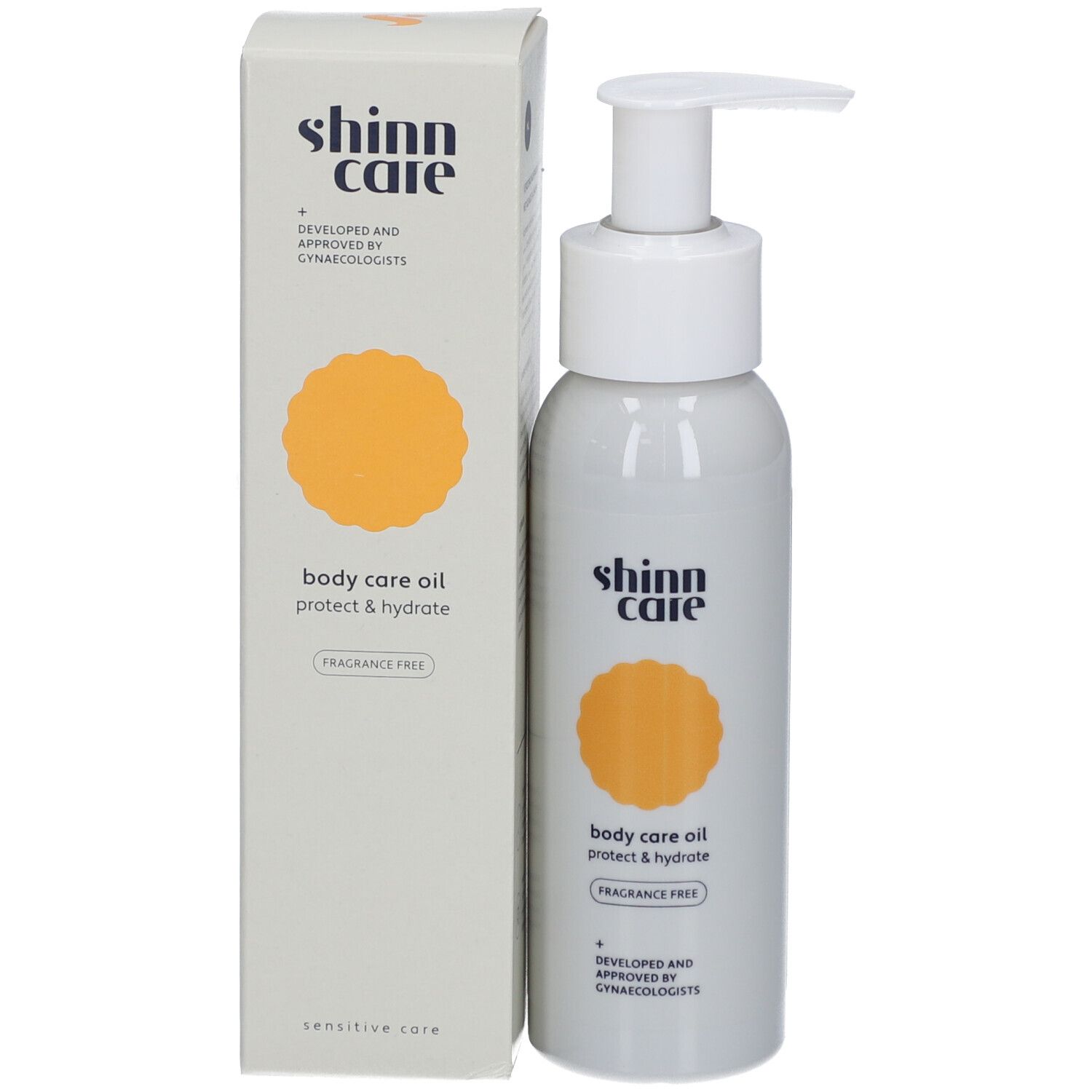 Graue Flasche mit weißem Pumpkopf und Karton. Aufschrift: shinn care, body care oil, protect & hydrate, fragrance free.