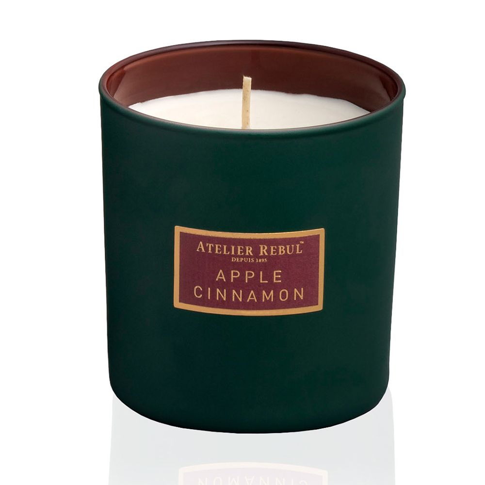 Groene geurkaars met rood etiket. Tekst: ATELIER REBUL, APPLE CINNAMON.