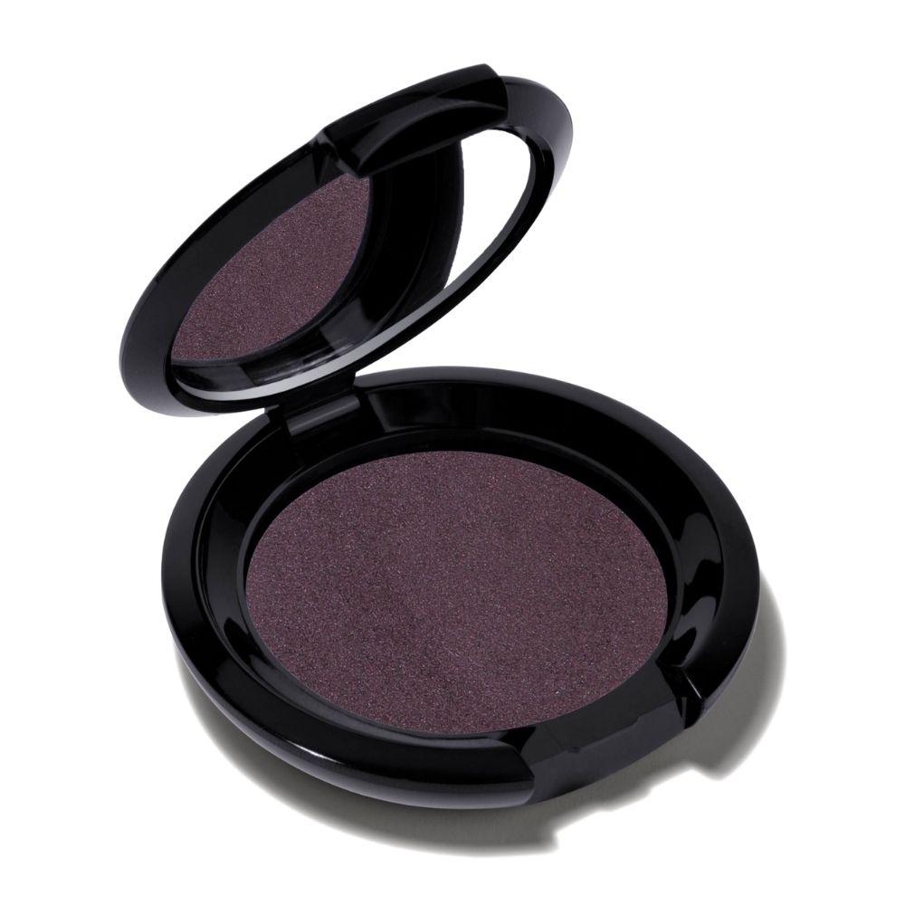 Fard à paupières violet rond dans un boîtier noir. Miroir dans le couvercle. Sur fond blanc.