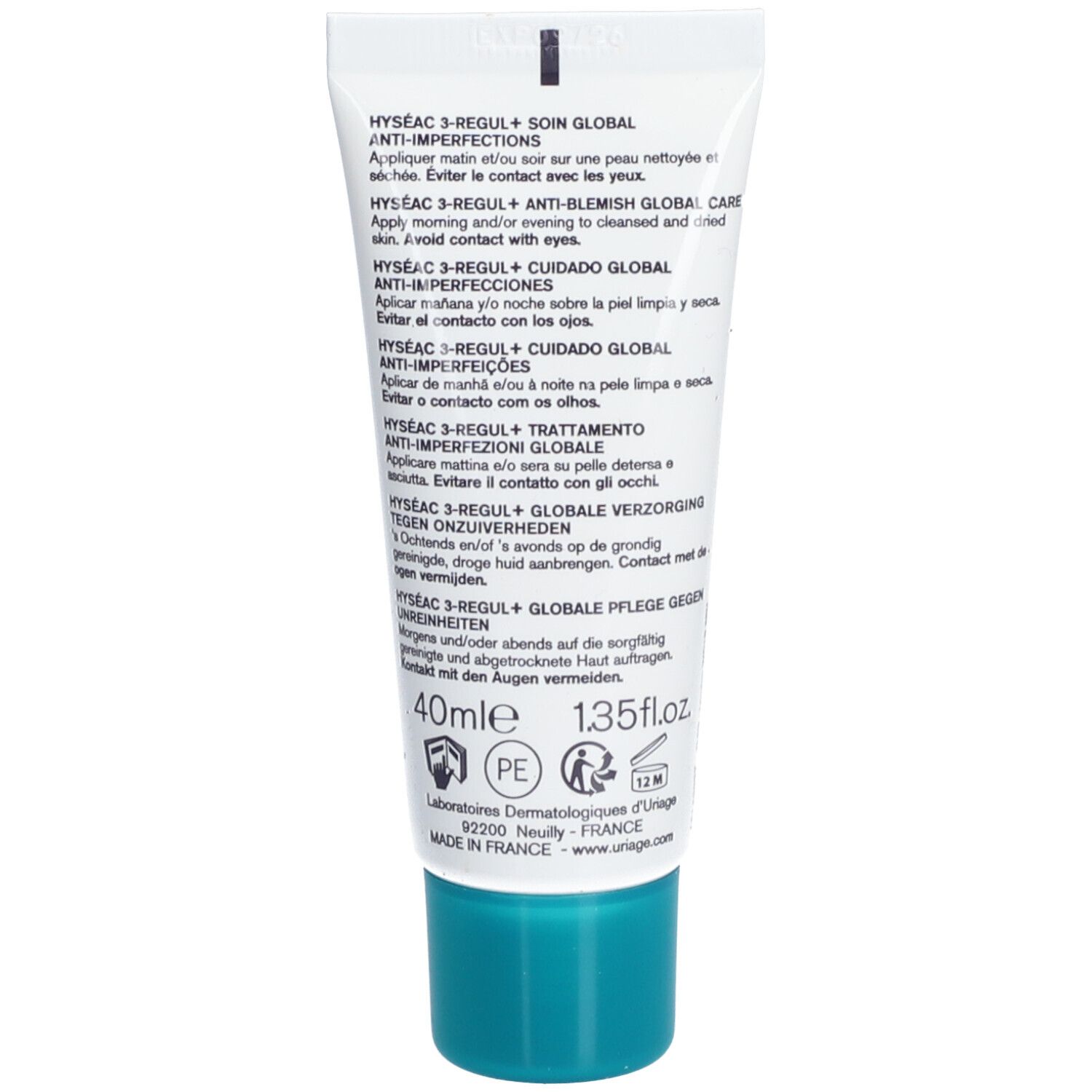 Dos du tube de crème. Texte multilingue, instructions et informations produit. Bouchon turquoise.