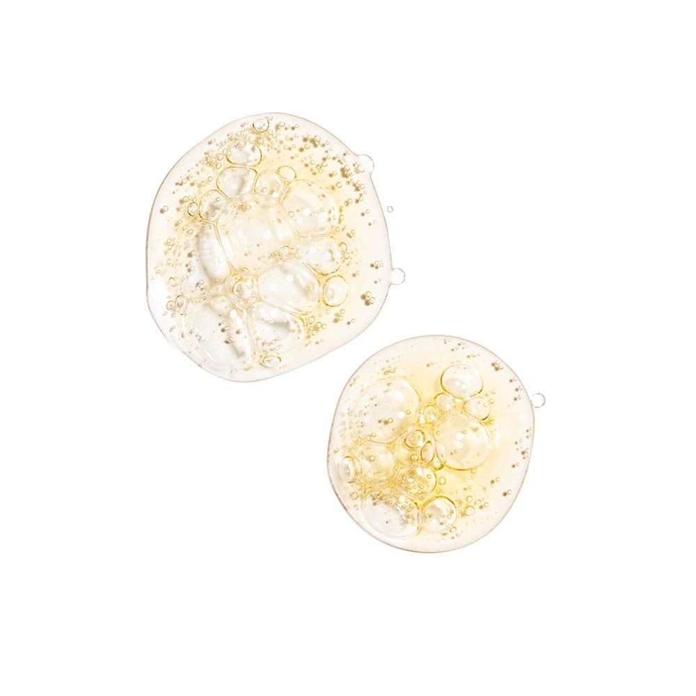 Deux gouttes de liquide jaunâtre sur fond blanc. Bulles visibles.