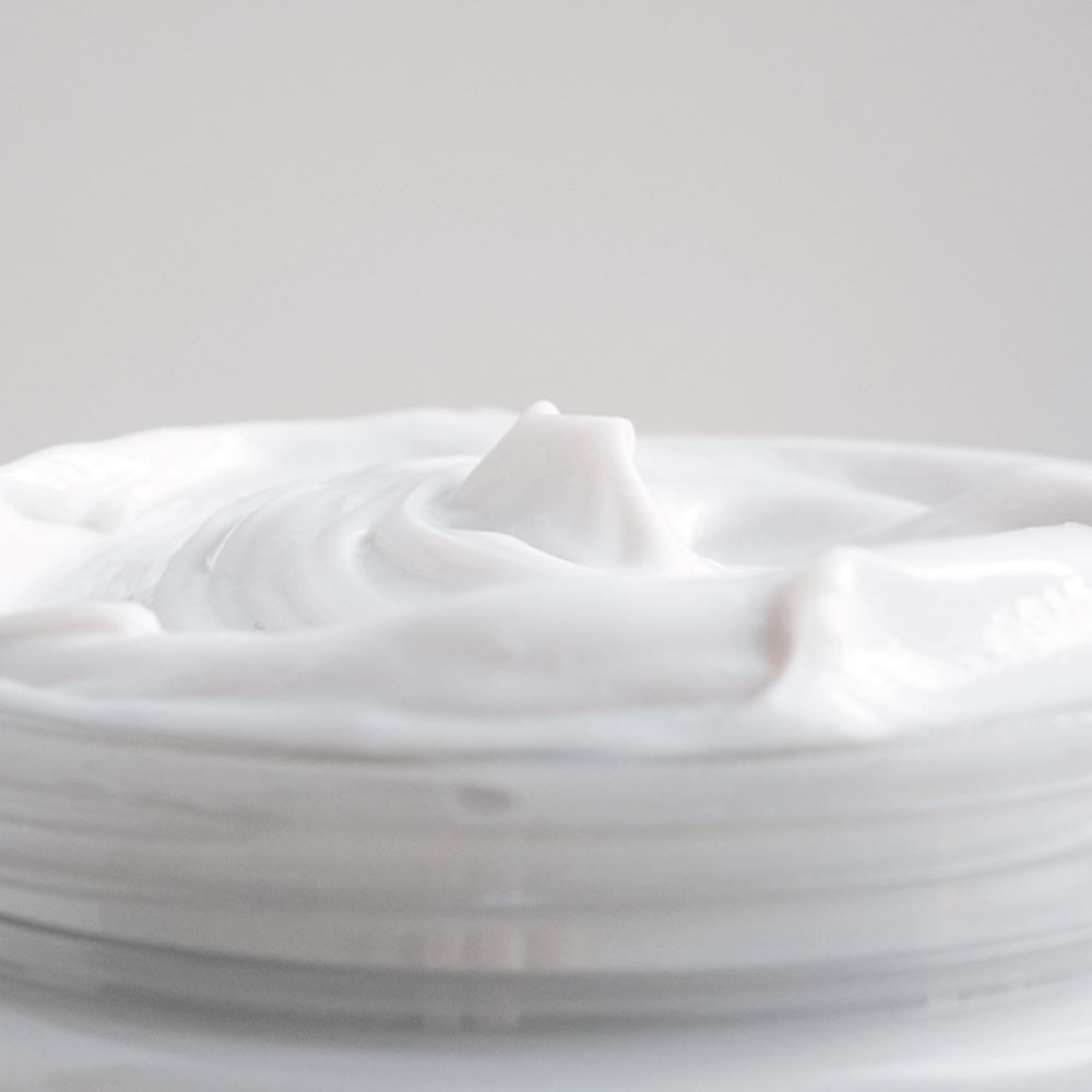 Gros plan du pot de crème. Texte: Le masque-soin pour les cheveux. Logo MÊME. 99%.
