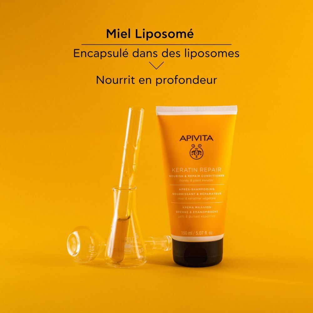 Tube jaune, bouchon noir. Texte: Apivita, Keratin Repair Conditioner. Avec matériel de laboratoire.