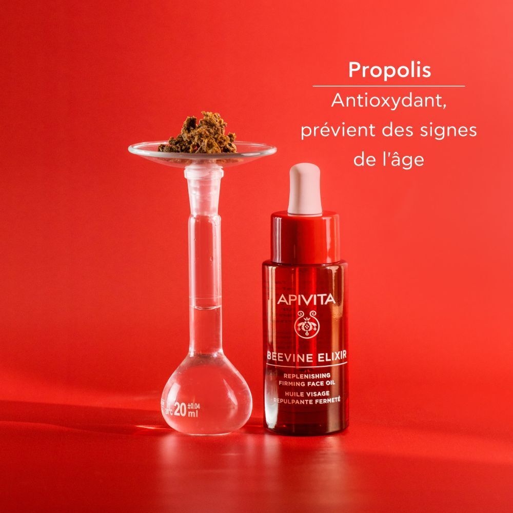Flacon rouge avec compte-gouttes blanc. Inscription: APIVITA BEEVINE ELIXIR. Huile visage.