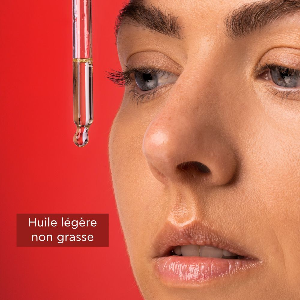 Flacon rouge avec compte-gouttes blanc. Inscription: APIVITA BEEVINE ELIXIR. Huile visage.