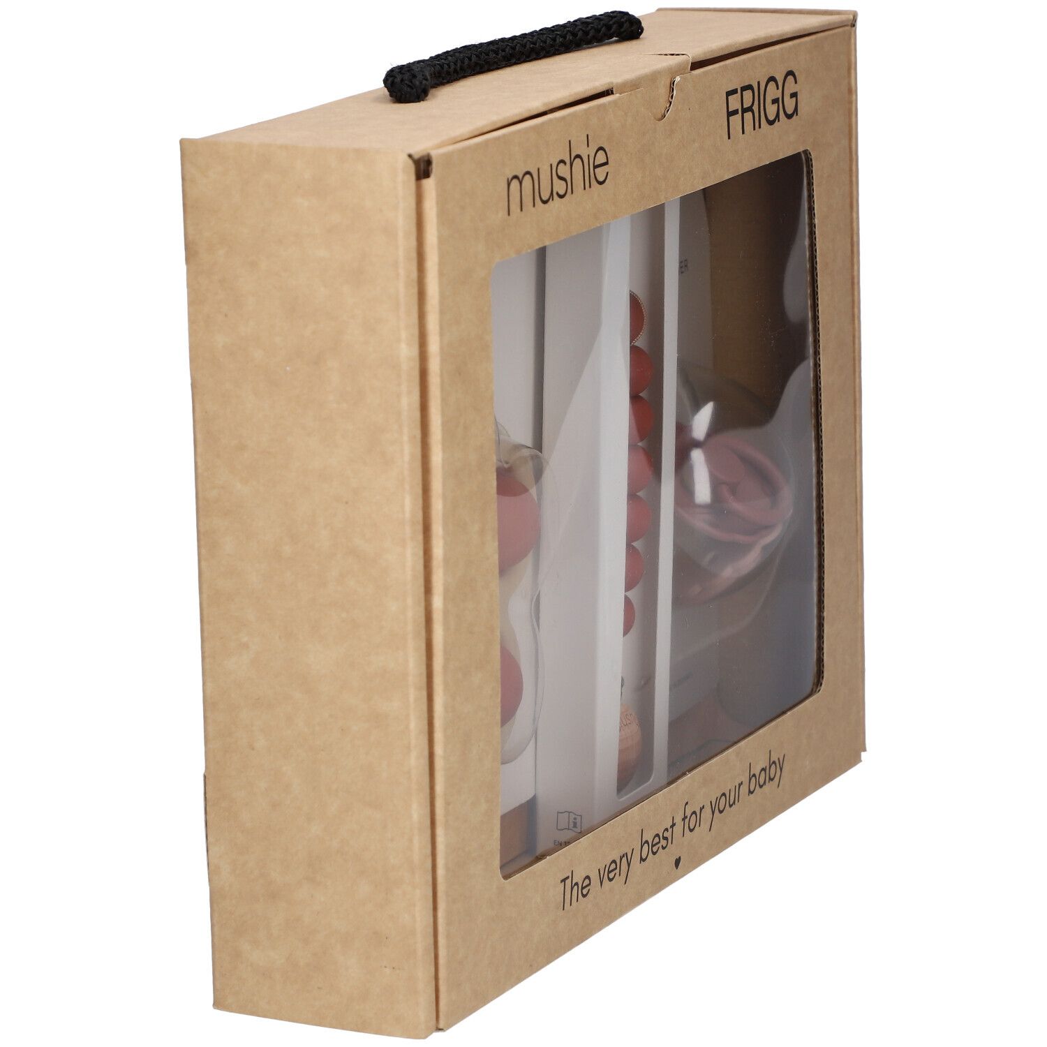 Coffret cadeau, vue latérale. Fenêtre transparente montrant des articles pour bébés. Marques : Mushie, FRIGG. Poignée noire.