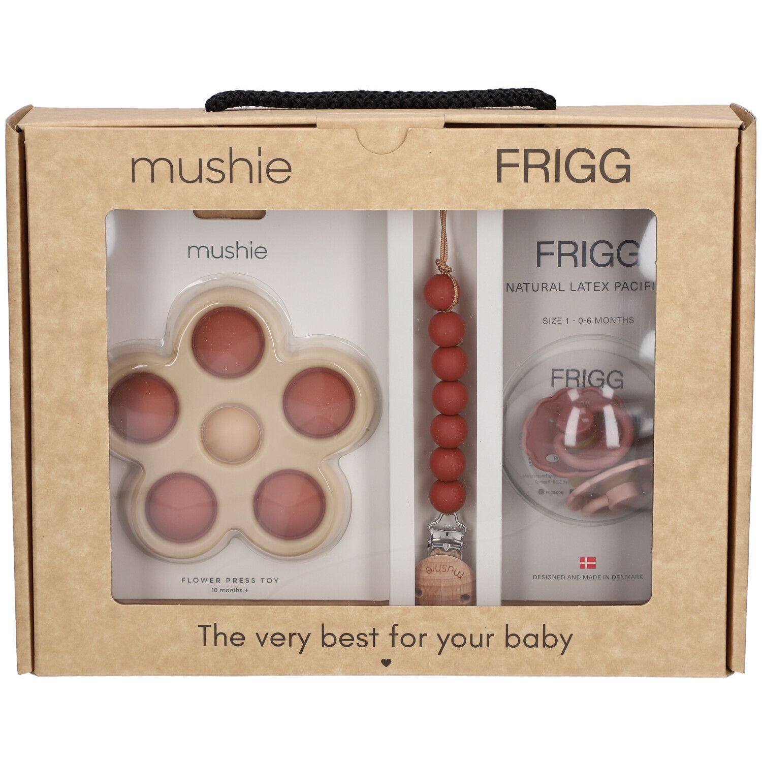 Coffret cadeau bébé. Visible : sucette, anneau de dentition en forme de fleur et attache-sucette. Marques : Mushie, FRIGG.