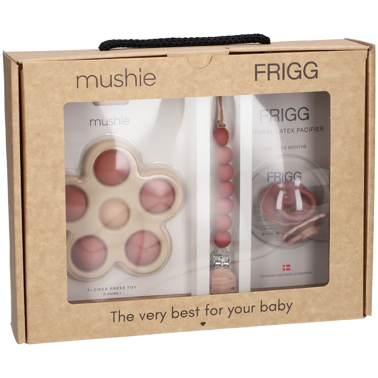 Coffret cadeau bébé. Visible : sucette, anneau de dentition en forme de fleur et attache-sucette. Marques : Mushie, FRIGG.