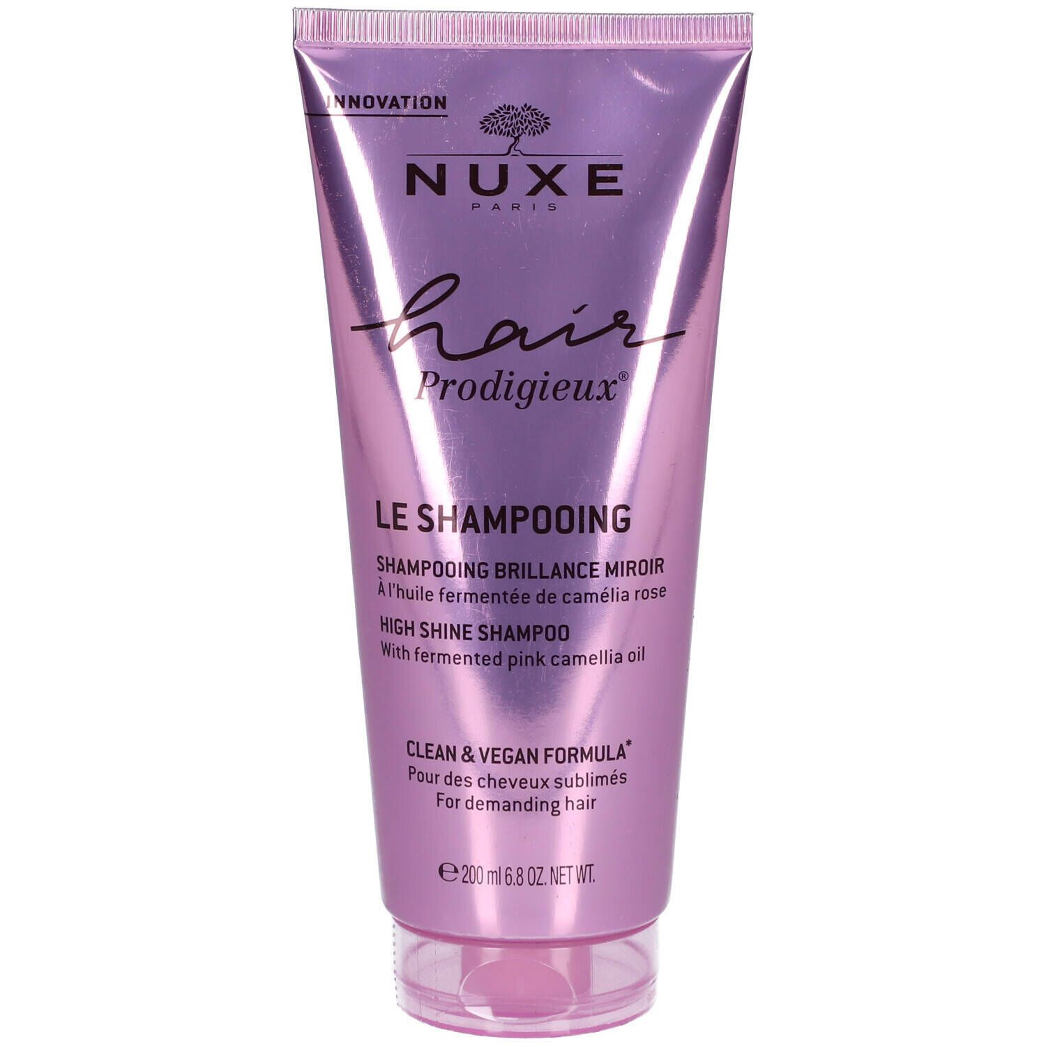 Tube rose avec texte Nuxe Hair Prodigieux, Le Shampooing. Contient du texte en anglais et en français. Bouchon transparent.