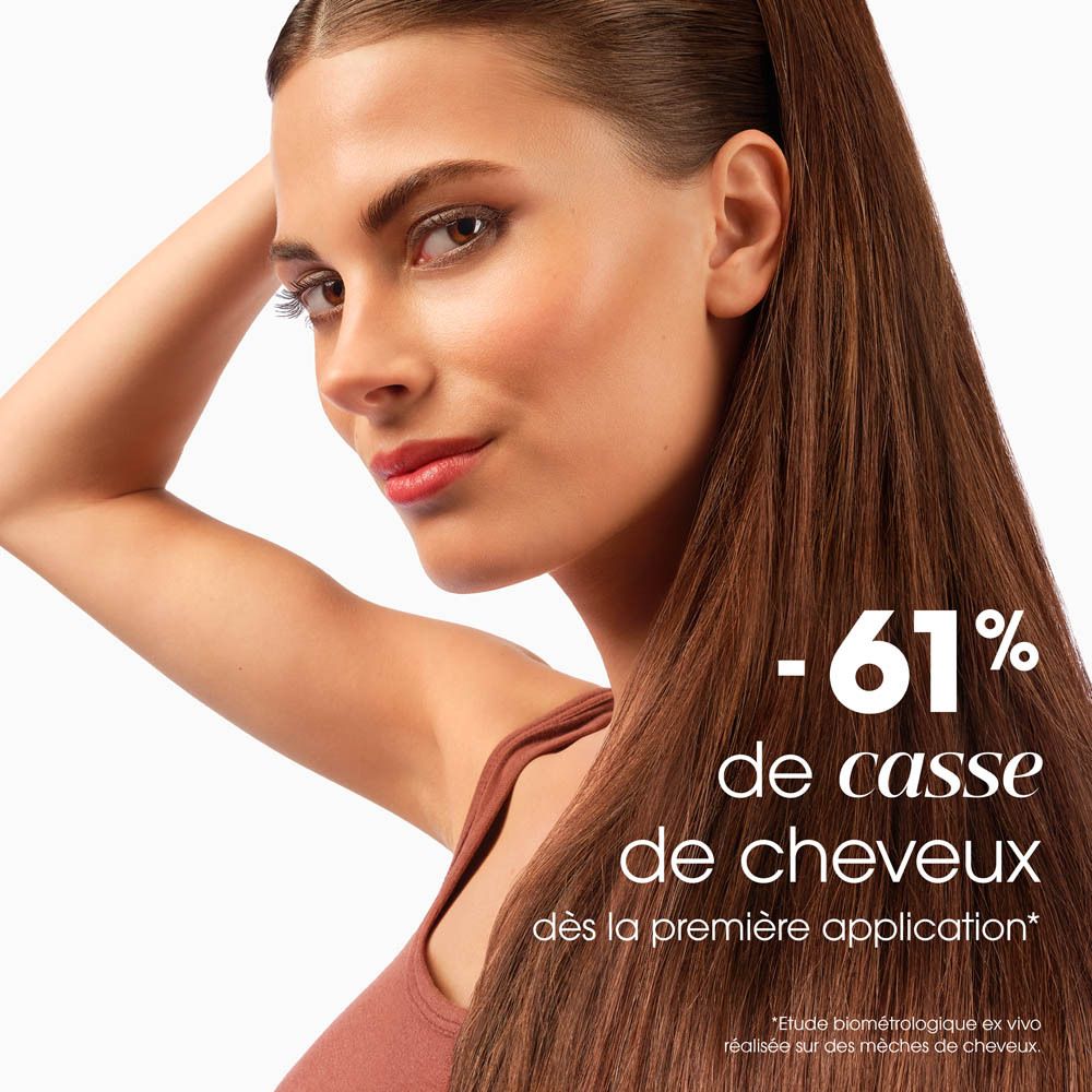 Femme aux cheveux bruns. Texte: -61% de casse des cheveux.