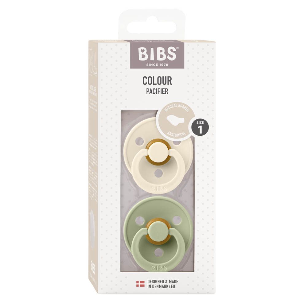 Emballage avec deux sucettes. Logo BIBS, 'COLOUR PACIFIER', taille 1. Sucettes ivoire et verte visibles.