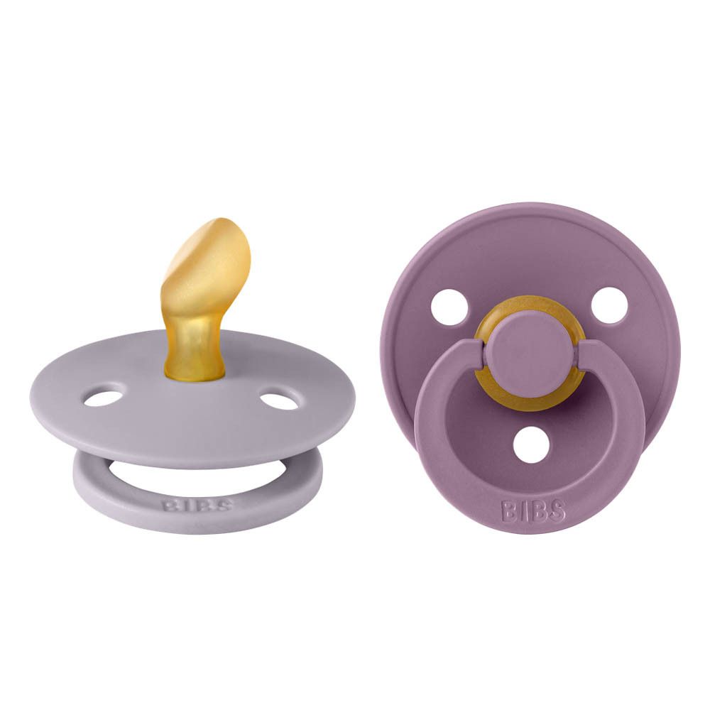 Zwei Schnuller, einer mit gelbem Sauger, der andere mit lila Ring. BIBS-Logo.