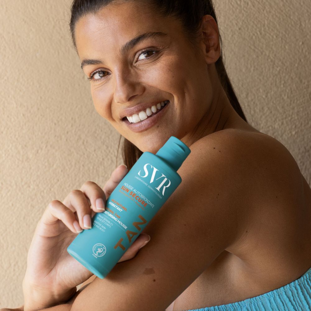 Flacon turquoise avec texte blanc. Inscription : SVR, Mousse Autobronzante Sun Secure, Natural Tan, Moisturising Mousse. Avec le mot TAN.