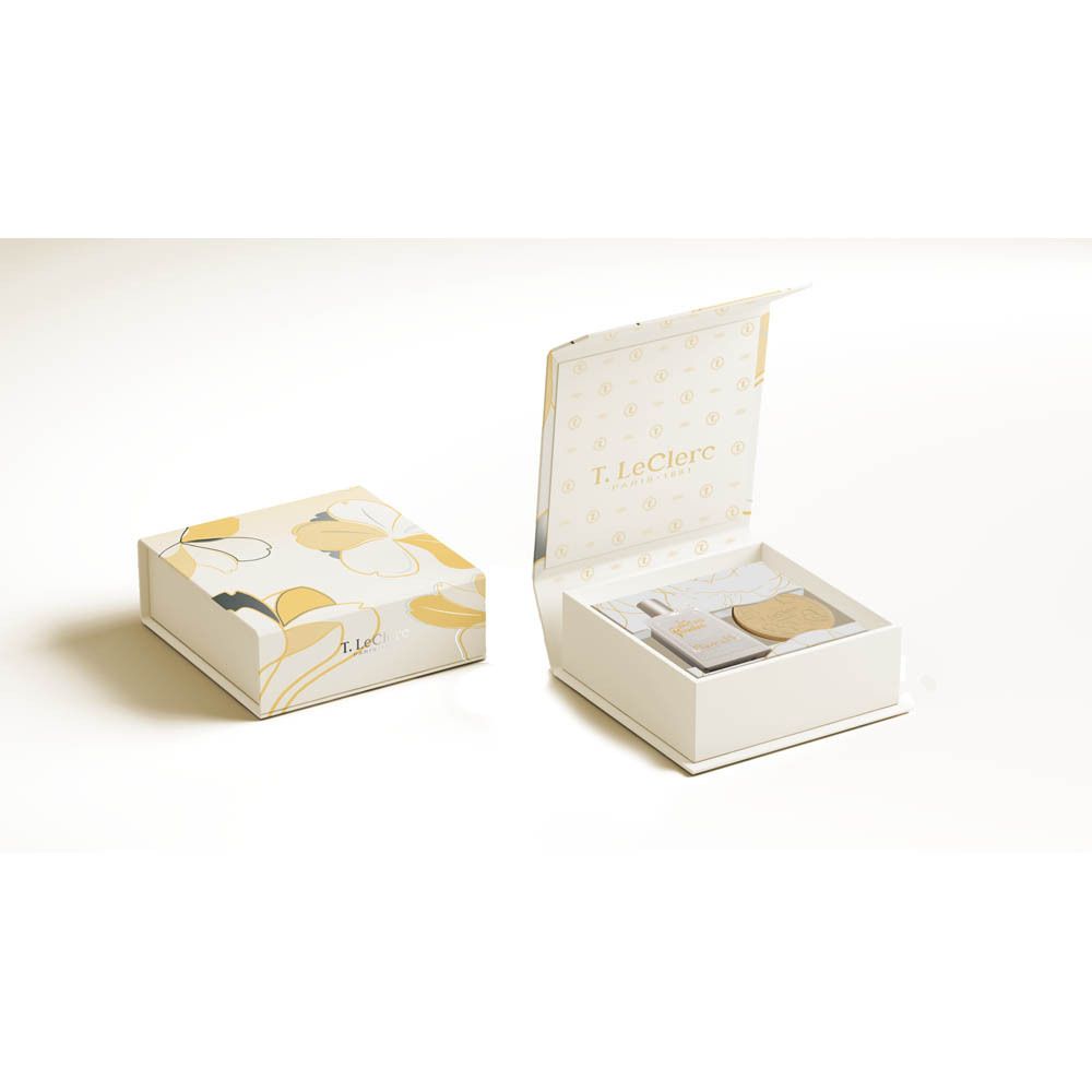 Coffret ouvert avec parfum et céramique. Contient flacon, céramique et accessoires. Blanc et jaune, motif floral.