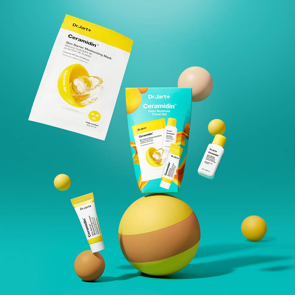 Dr. Jart+ CERAMIDIN™ Hello Moisture Travel Set. Éléments jaunes, jouets, appareil photo. Fond jaune.
