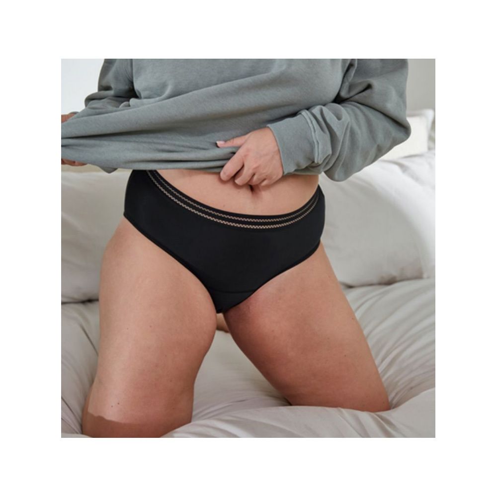 Zwarte menstruatieslip. Saforelle. Close-up. Op bed.