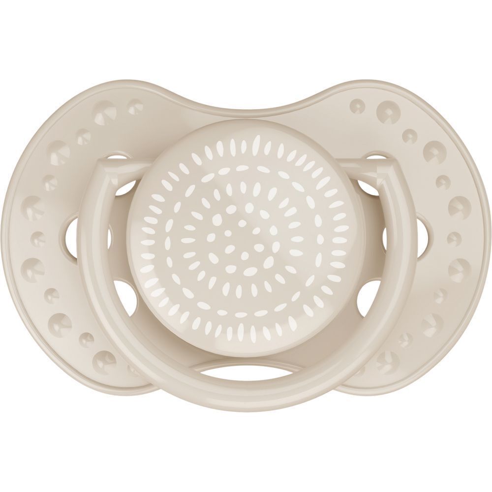 Sucette crème. Forme ronde avec tétine plate et poignée. Motif blanc à pois sur la tétine.