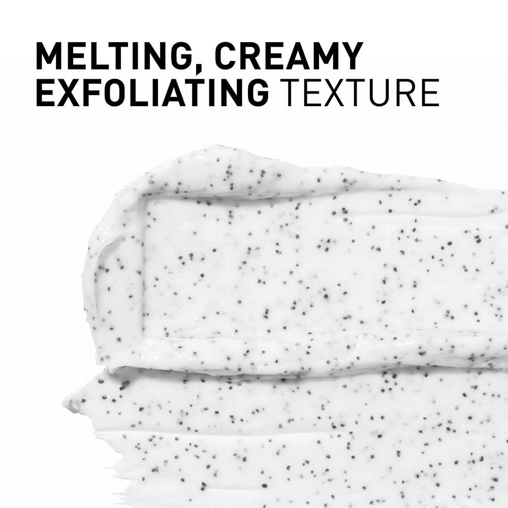 Texture de la crème exfoliante. Crémeuse, avec de petites particules noires.