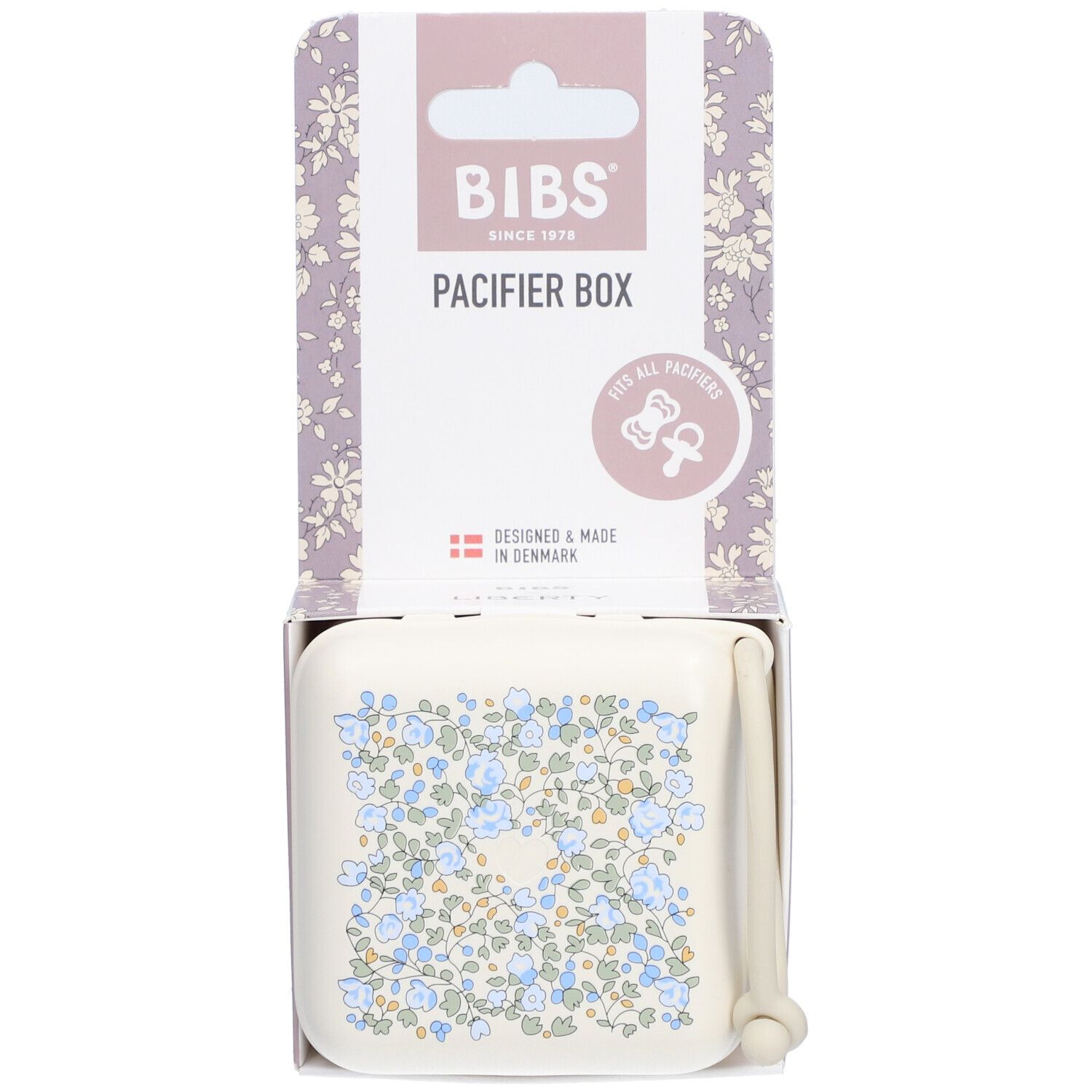 BIBS Schnullerbox in Verpackung. Beige Box mit blauem Blumenmuster. Deckel mit Griff. Verpackung mit Logo.