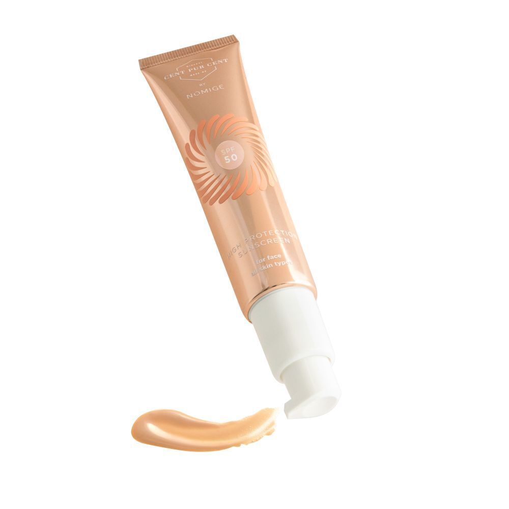 Tube beige avec pompe blanche et trace de produit. Inscription SPF 50. Nom non visible.