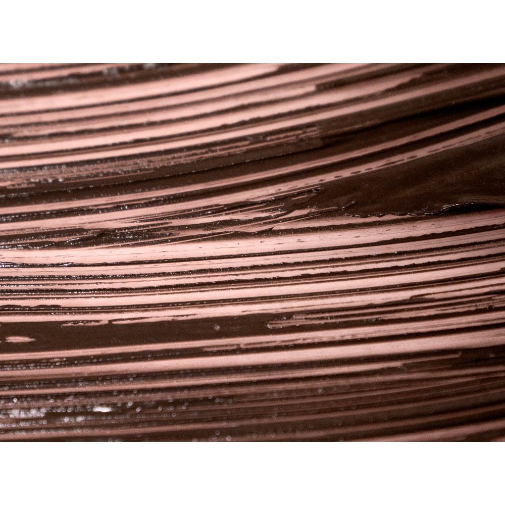 Gros plan sur des traits de mascara. Couleur marron. Sur fond rose.