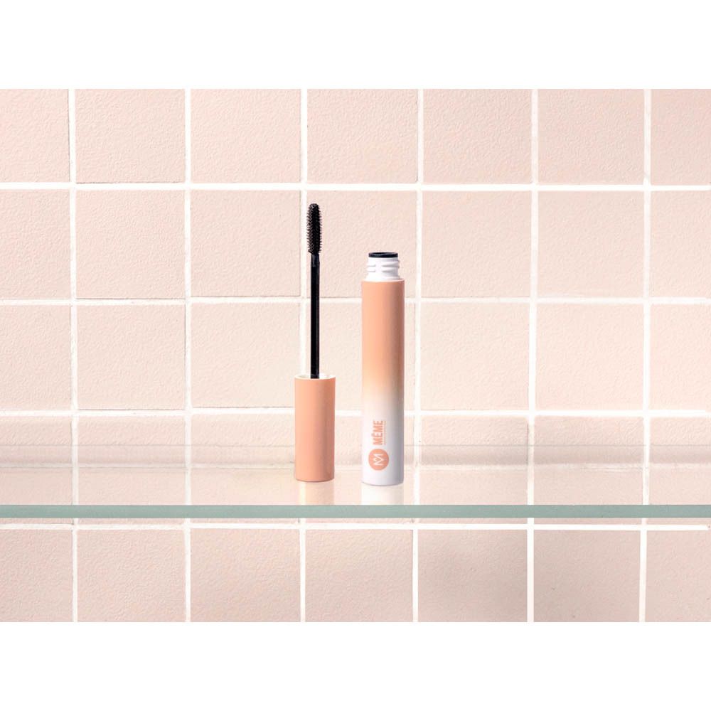 Tube et brosse de mascara sur étagère en verre. Carrelage rose en arrière-plan. Marque : MÊME.