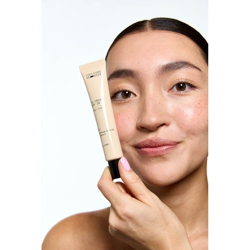 Tube beige avec bouchon noir. Inscription: CC CREAM SPF 30, 04 Sand. Marque: Couleurs de Noir.