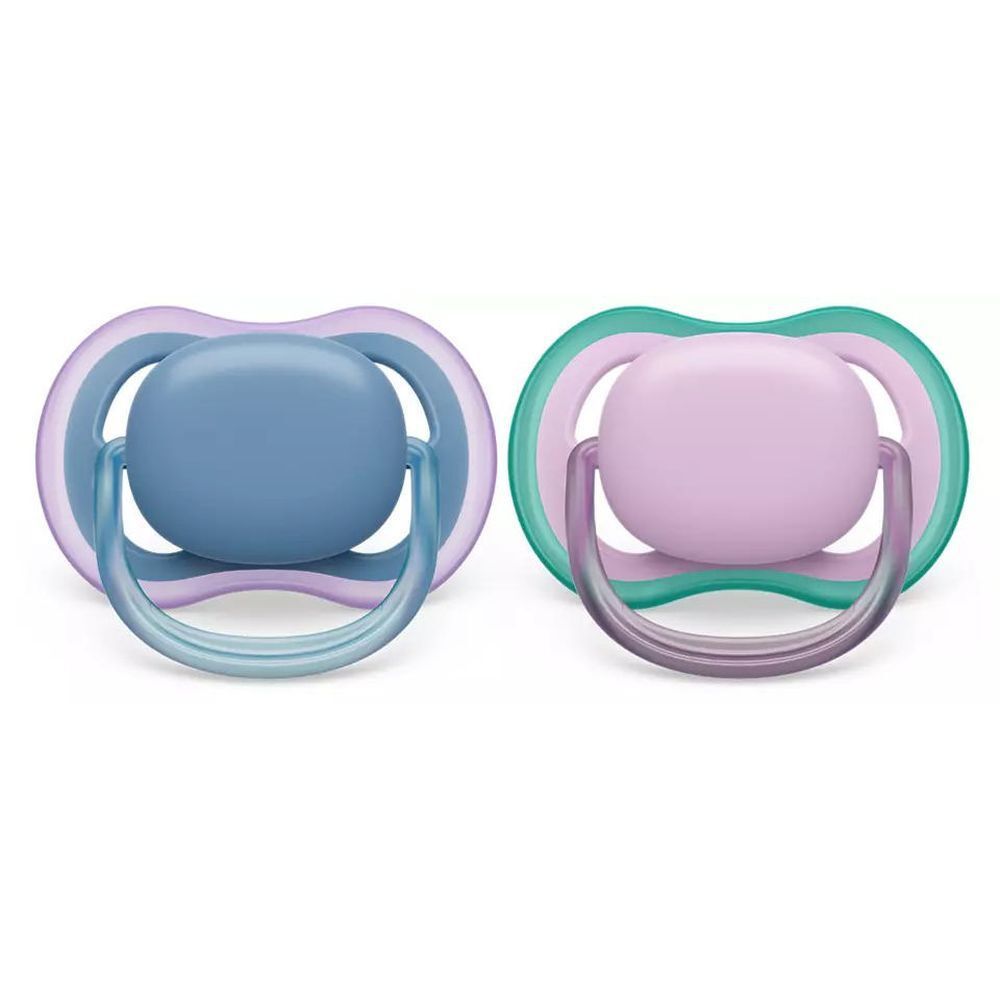 Zwei Schnuller, blau und rosa, mit farbigen Rändern und Griffen. Die Schnuller haben einen runden Sauger.