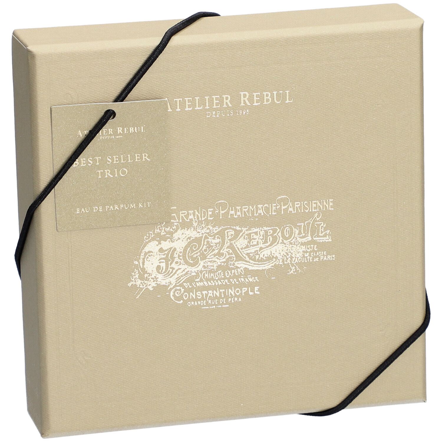 Coffret beige avec élastique noir. Étiquette : Atelier Rebul, Best Seller Trio, Eau de Parfum Kit.