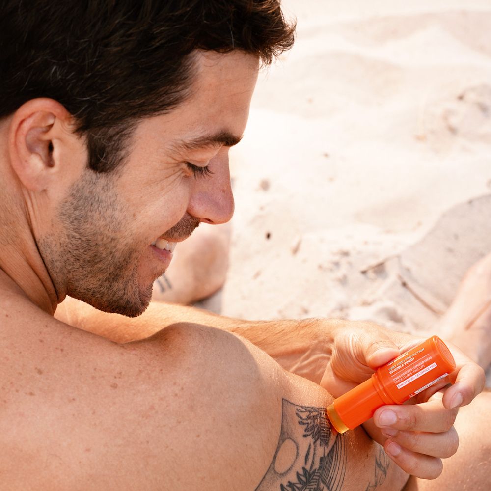 Homme appliquant SVR Easy Stick SPF50+ sur le bras.