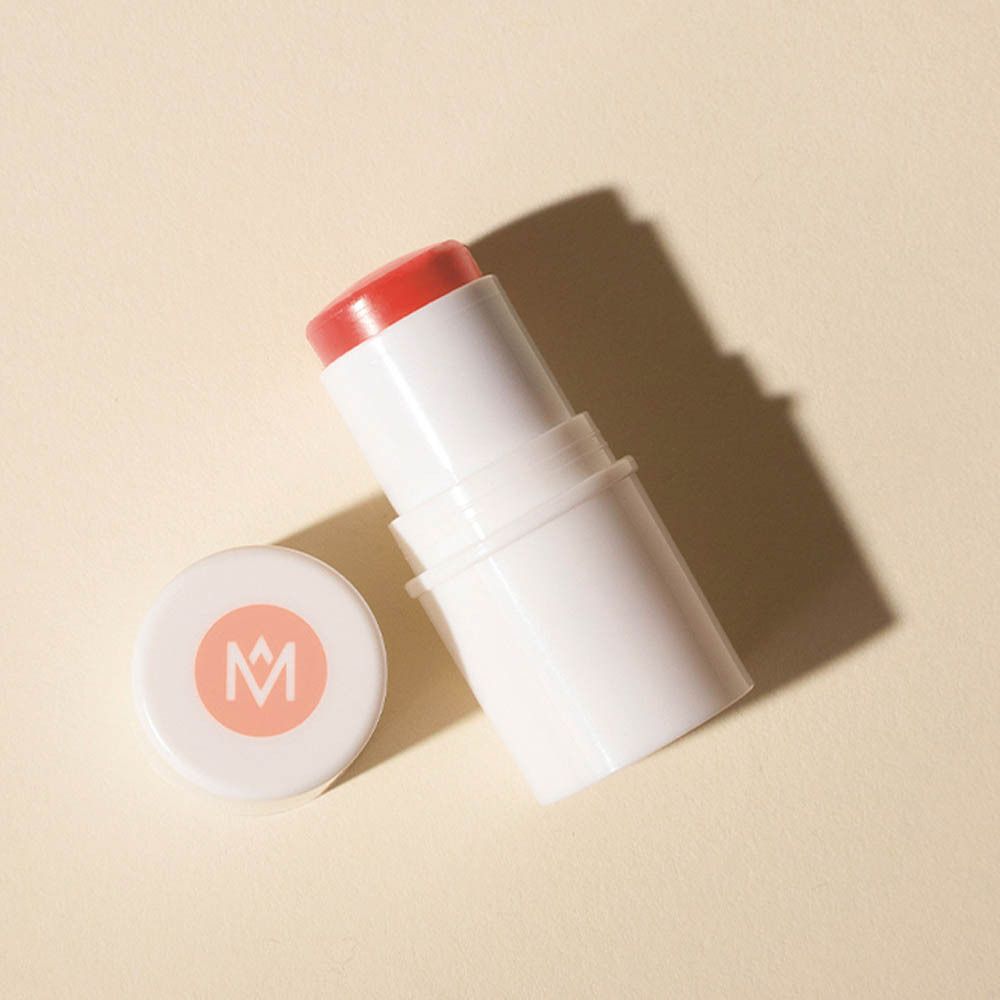 Stick de blush et couvercle. Récipient blanc avec couvercle rose. Sur fond clair.