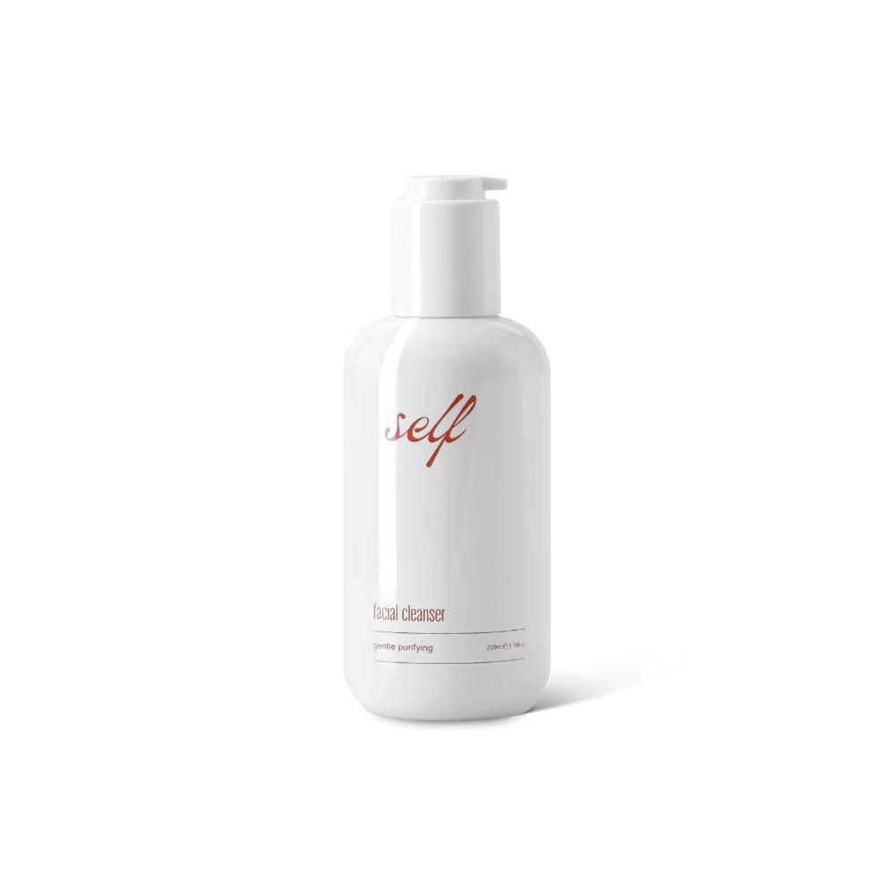 Witte fles met rode tekst "self" en "facial cleanser". Pompdop. Opschrift "gentle purifying".