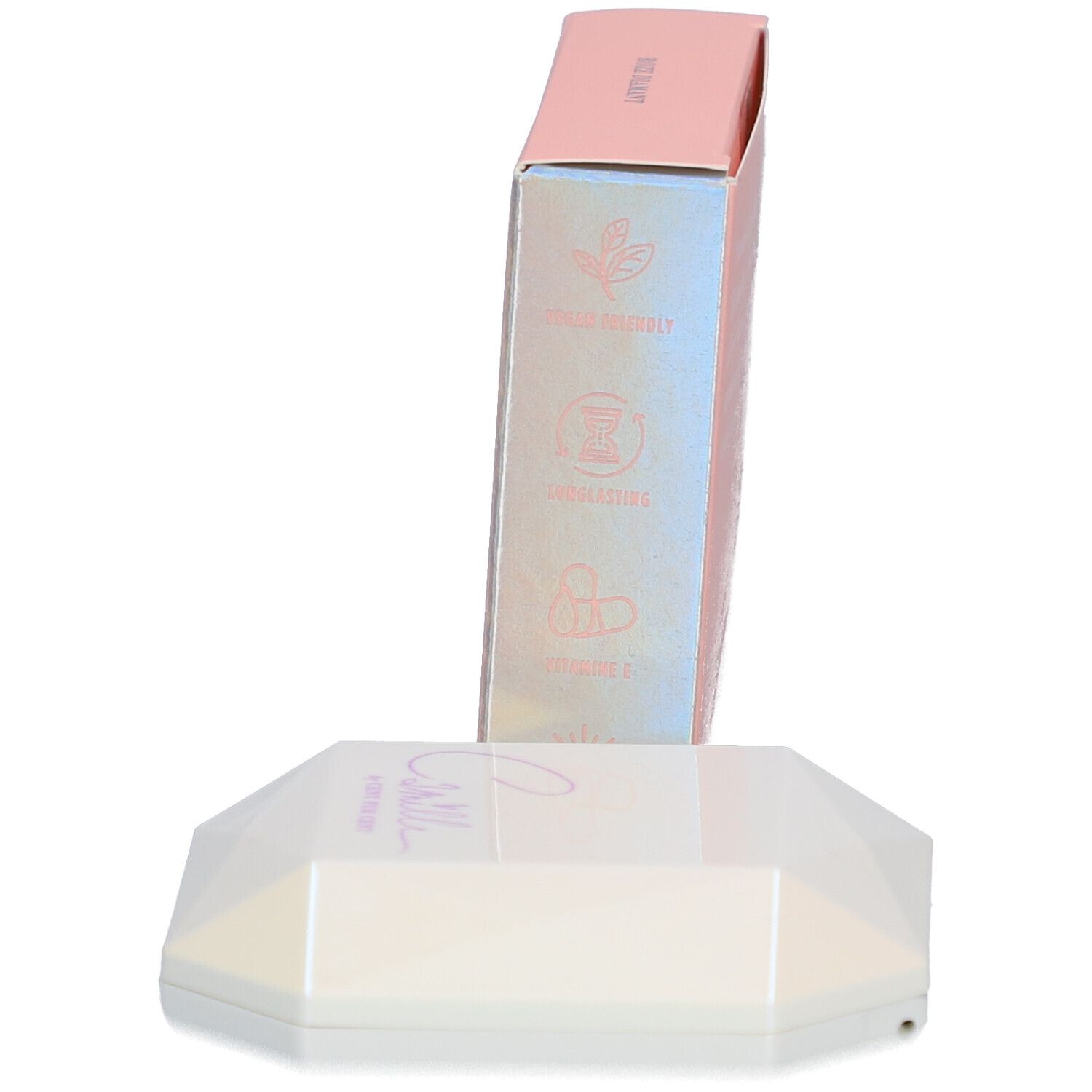 Rosa Schachtel und weiß-schimmernder Highlighter. Auf der Schachtel stehen Symbole.