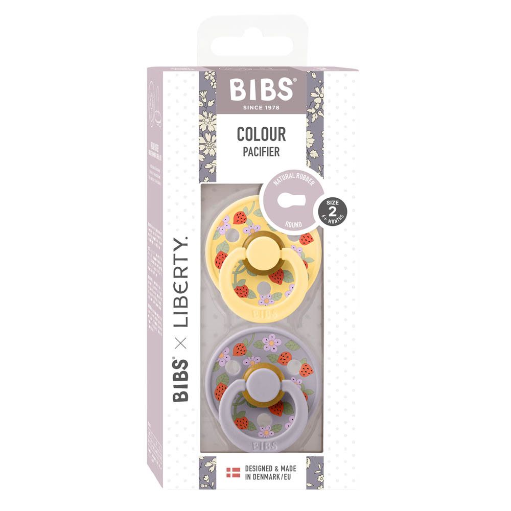 Verpackung mit zwei Schnullern. Gelber und lila Schnuller mit Erdbeer- und Blumenmuster. Größe 2.