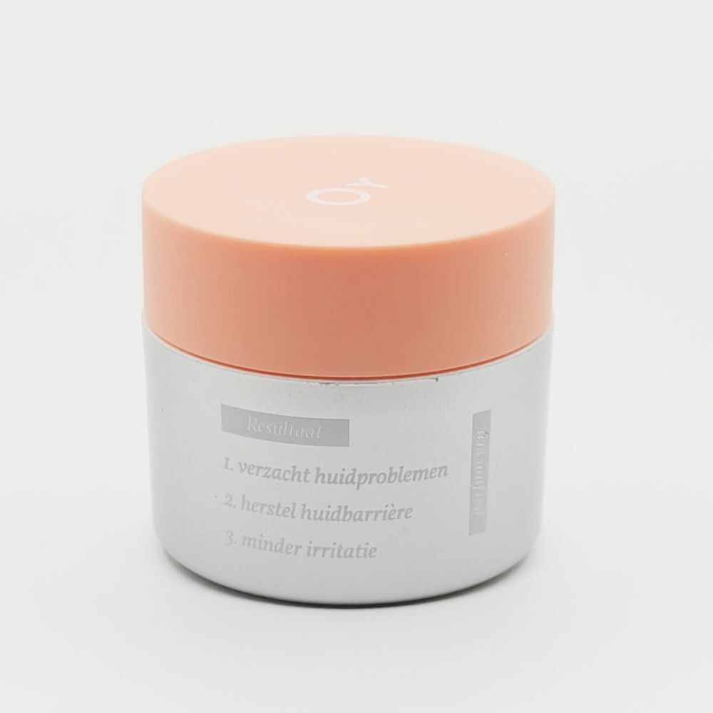Crèmepot met oranje deksel. "FACE WASH SENSITIVE" staat op de pot.