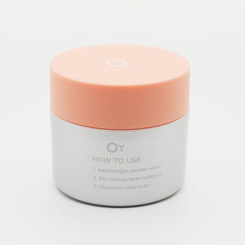 Pot de crème avec couvercle orange. "OY" et "HOW TO USE" sont écrits sur le pot.