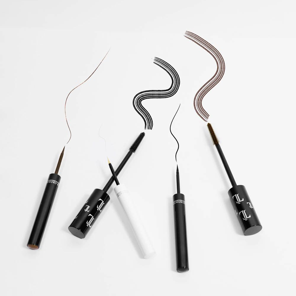 Diverse cosmetische producten, waaronder mascara en eyeliner, op witte achtergrond.