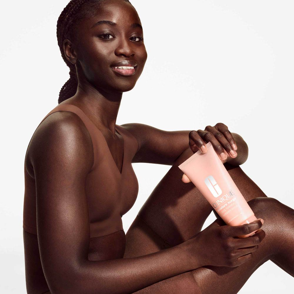 Clinique Moisture Surge Body Hydrator Tube mit herausdrückender Creme.