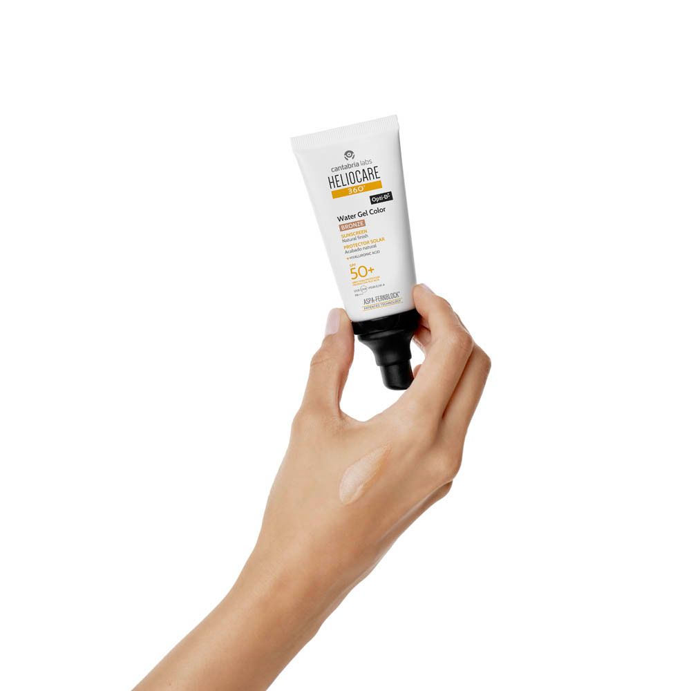 Hand met tube Heliocare 360° Water Gel Color Bronze SPF50+. Product aangebracht.