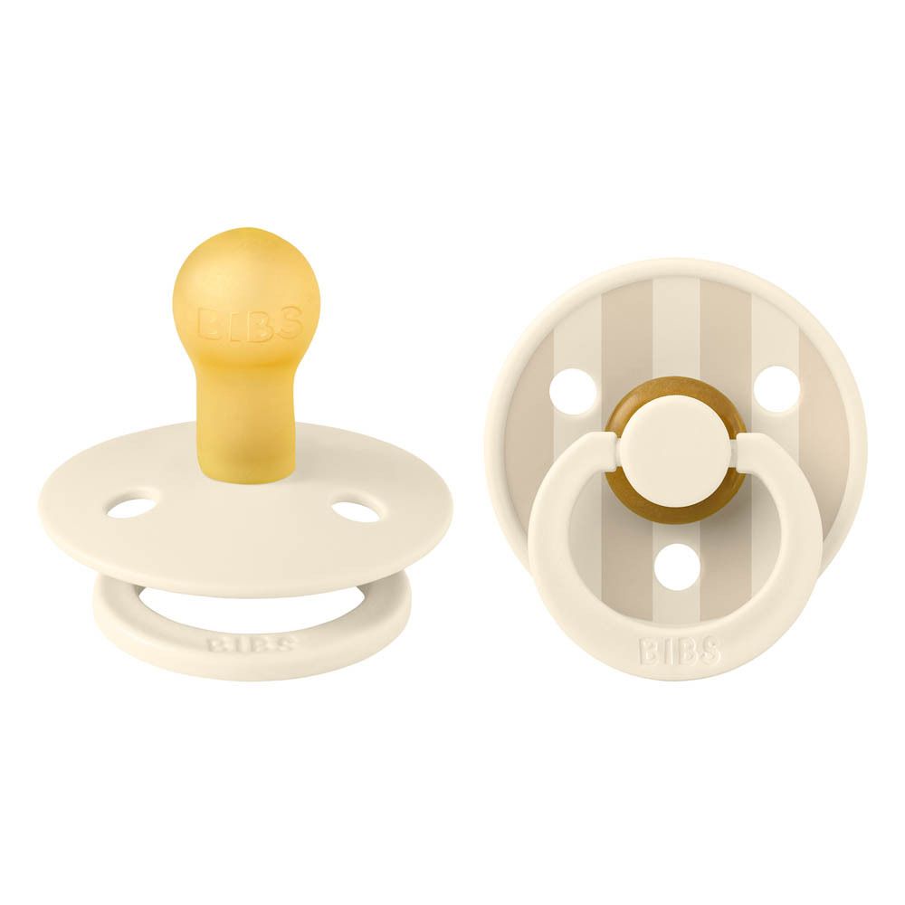 Deux sucettes. Tétine jaune, bouclier crème à rayures. Marque BIBS.