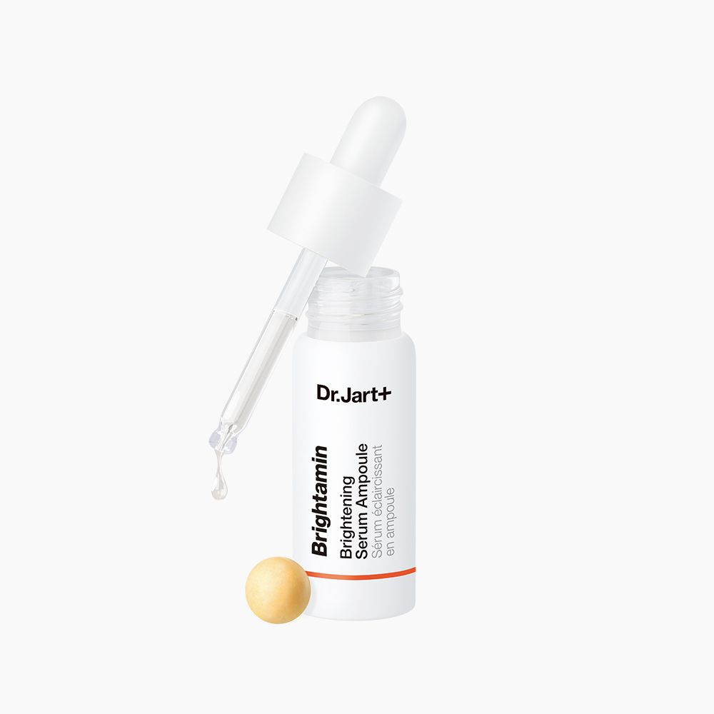 Kleine Flasche mit Pipette. Aufschrift: Dr.Jart+ Brightamin Brightening Serum Ampoule. Eine Kugel liegt daneben.