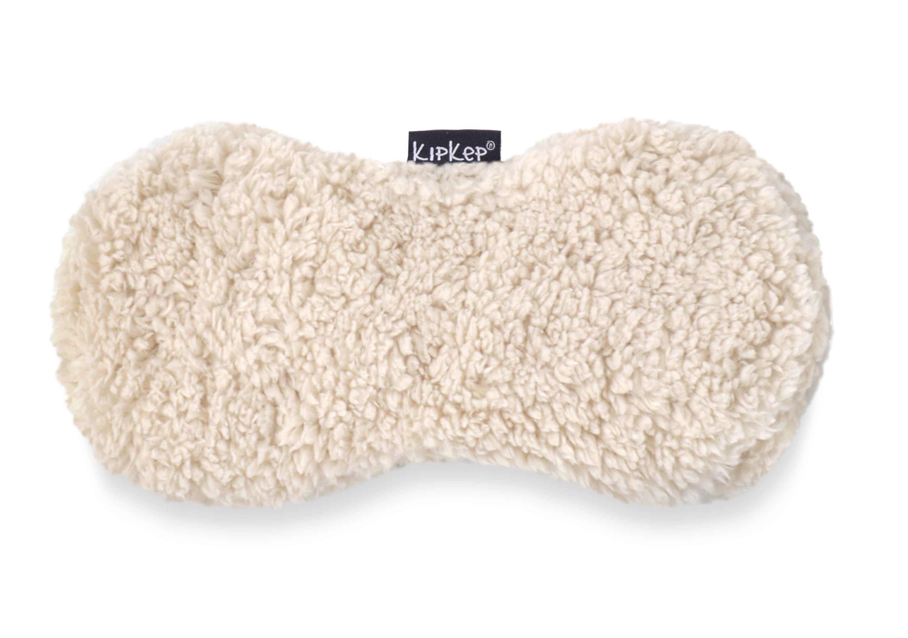 Coussin chauffant KIPKEP beige, aspect teddy. Forme ovale avec logo KIPKEP.