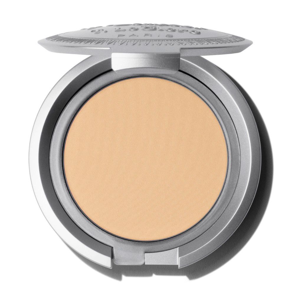 Poudre compacte de teinte claire dans un boîtier argenté. Couvercle estampé, ouvert.